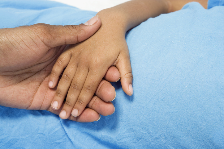 Close up of African boy holding parent's hand