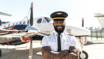Portrait of pilot in front of airplane