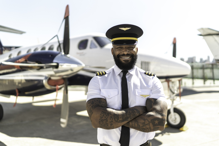 Portrait of pilot in front of airplane
