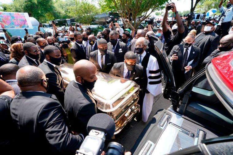 Pallbearers move the casket of George Floyd into a hearse as the Rev. Al Sharpton looks on following Floyd's funeral