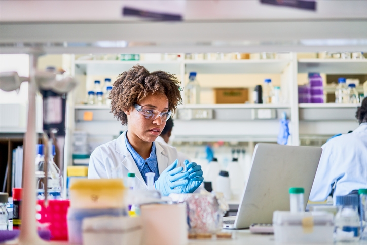 Young female scientist working with a laptop in a lab