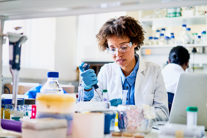 Young scientist using a pipette to analyzing a sample in a lab