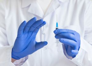 An ampule with a medicine or vaccine in the doctors hands.