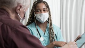 African descent doctor consults with Senior Caucasian patient.