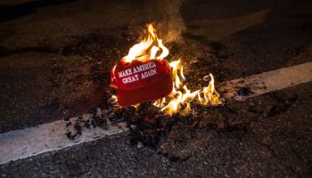 Black Lives Matter protesters burn a Trump Train hat prior...