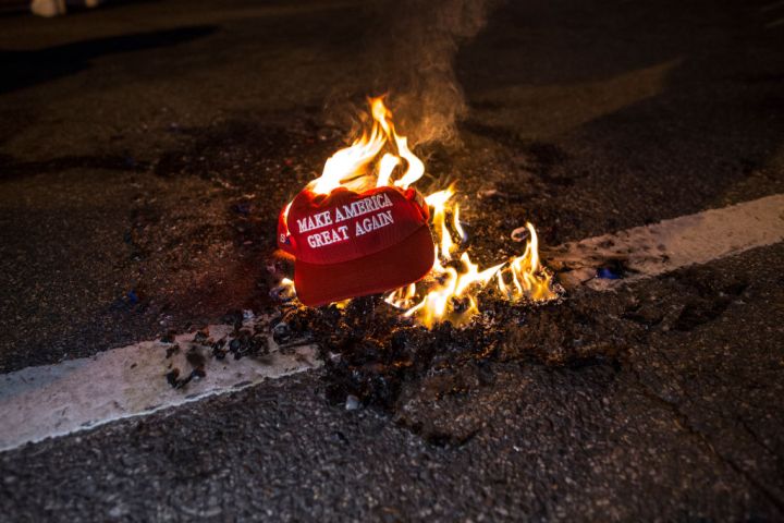 Black Lives Matter protesters burn a Trump Train hat prior...