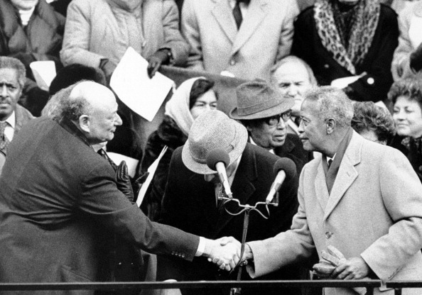 Dinkins at his Mayoral Inauguration on January 2, 1990, shaking hands with former Mayor Ed Koch.