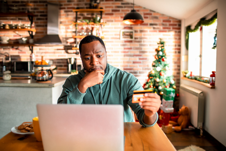 Young man doing online Christmas shopping