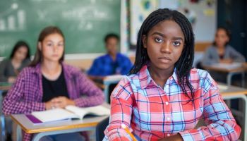 Portrait of concerned Black ethnicity student concentrating in classroom