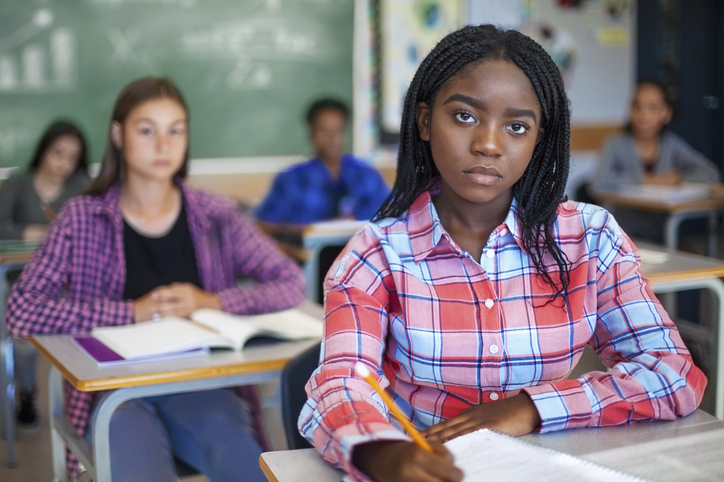 Portrait of concerned Black ethnicity student concentrating in classroom