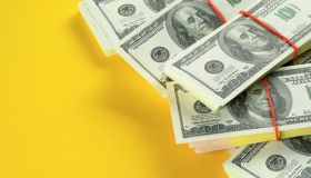 US dollars American Bills in Bundles On a Bright Yellow background.