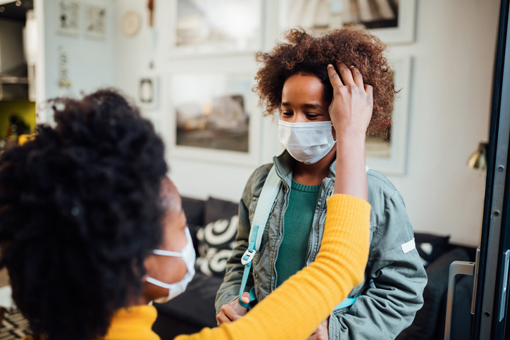 Mother preparing her daughter for school