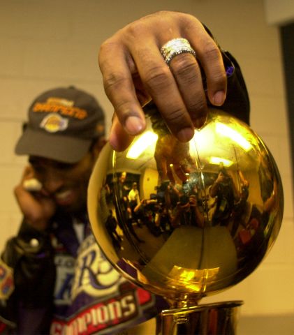 031395.SP.0615.lakers.21WS  Lakers Kobe Bryant Bryant hangs on to the Championship trophy after de