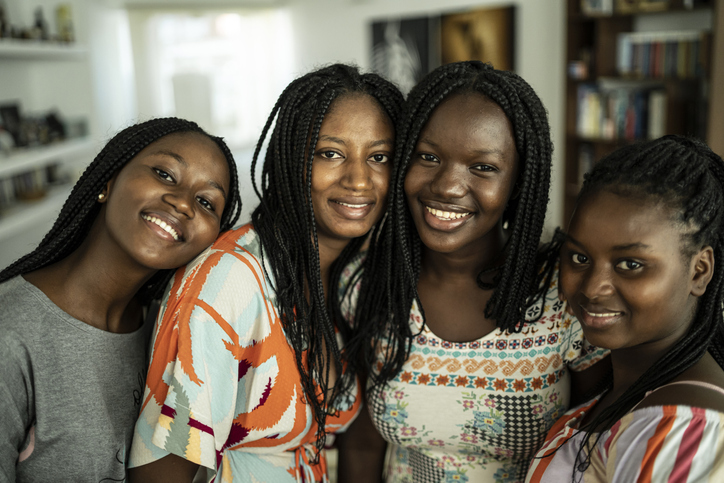 Four girlfriends embracing and taking selfie