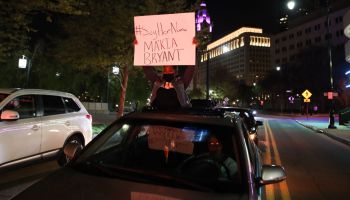 A protester holds a sign out of a car during the MaKhia...
