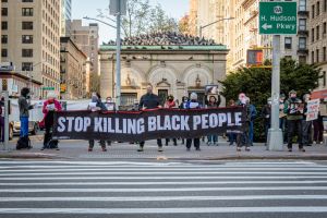 Participants seen holding a banner reading STOP KILLING...