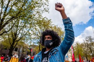 A man is seen raising his fist while wearing a BLM face mask...