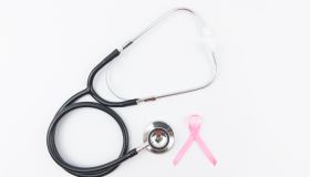 Sign of Breast cancer awareness month, pink ribbon with Stethoscope. White Background.
