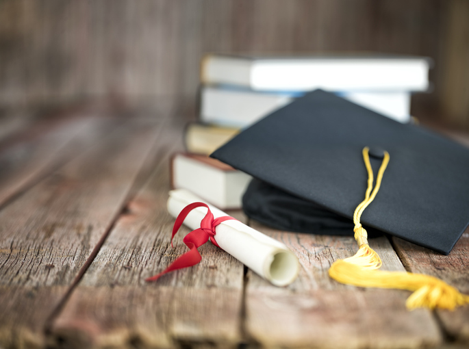 Graduation Cap and Diploma Concept on a Wood Background
