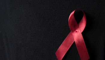 Close Up Of Aids Awareness Ribbon On Black Background