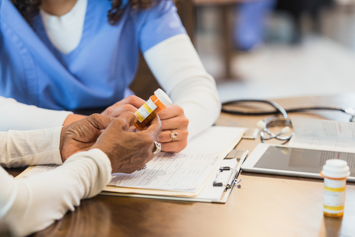 Unrecognizable senior woman asks nurse question about medication