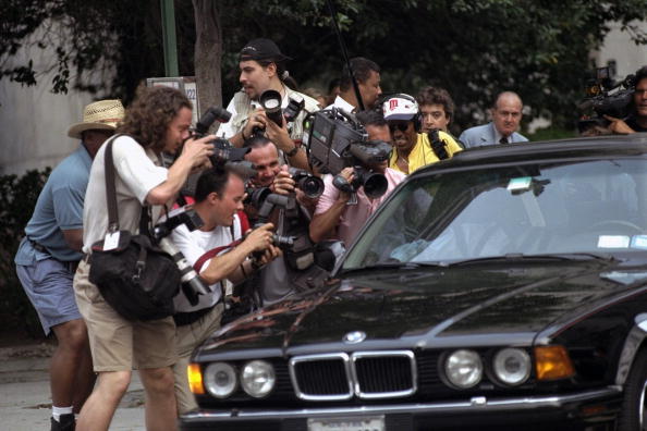Photographers and TV crews close in on Bill Cosby's car as h