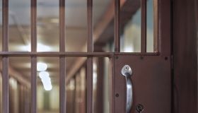 locked prison door with bars, hallway and prison cells