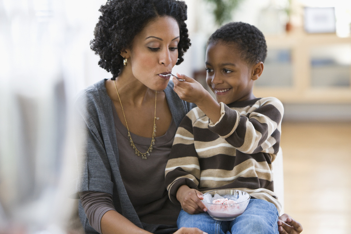 African American boy feeding mother ice cream