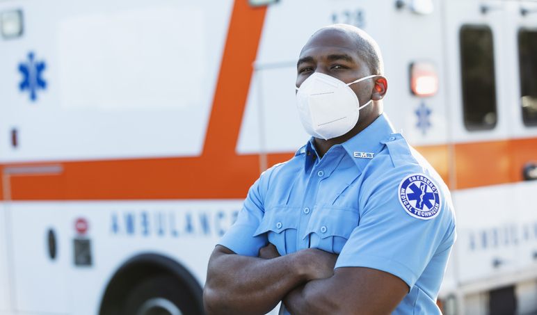 Paramedic in front of ambulance, with face mask