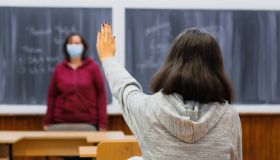 High school student with arm raised in classroom