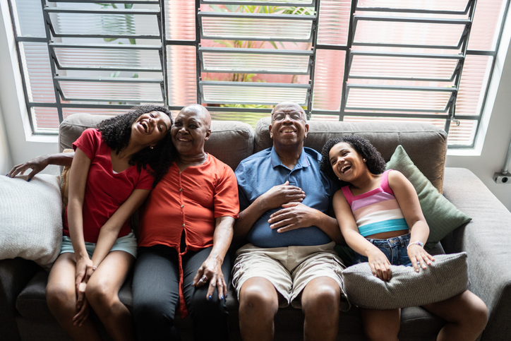 Grandparents and granddaughters laughing at home