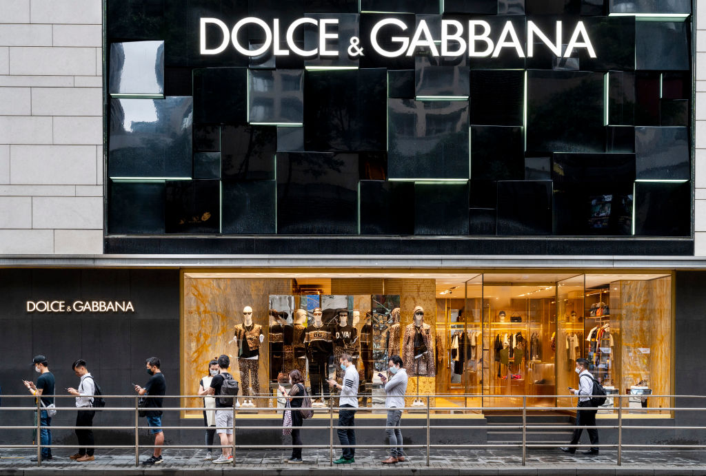 Shoppers stand in front of the Italian luxury fashion house...