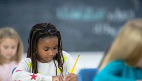 Multi-Ethnic Elementary Students Writing in Class
