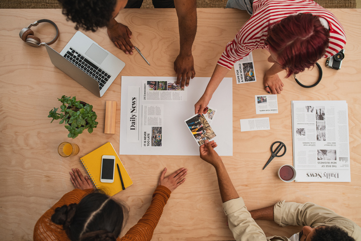 Top view of unrecognizable magazine editors indoors in office, working.