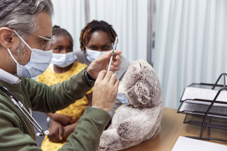 Pediatrician preparing to give child a COVID-19 vaccination