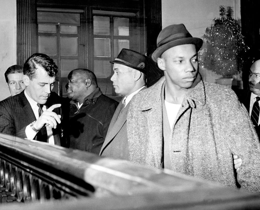 A detective talks to Black muslims William Gaines (left), Th