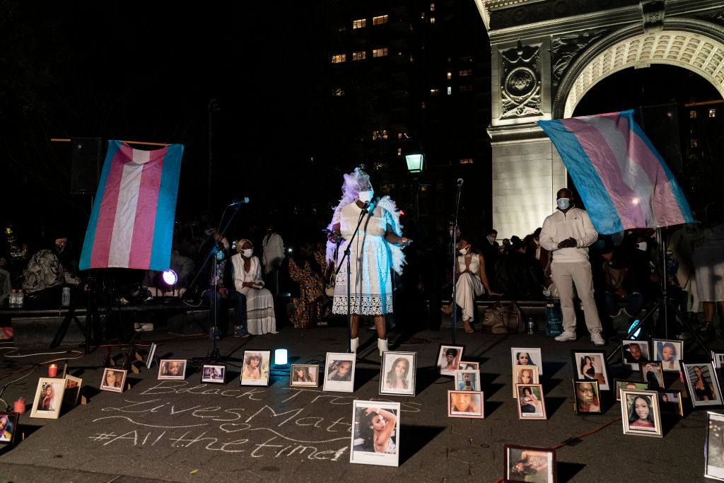 Frames with portraits of victims and candle light. People...