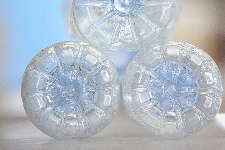 Bottom view of three used empty plastic bottles