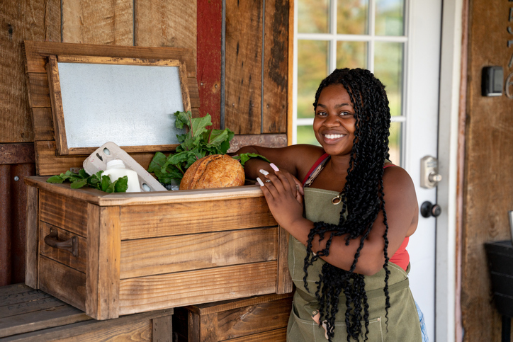 Pretty African American Woman in her Twenties Posing in front of her Storefront selling Organic and Sustainable Produce and Dairy Products to a Local Community