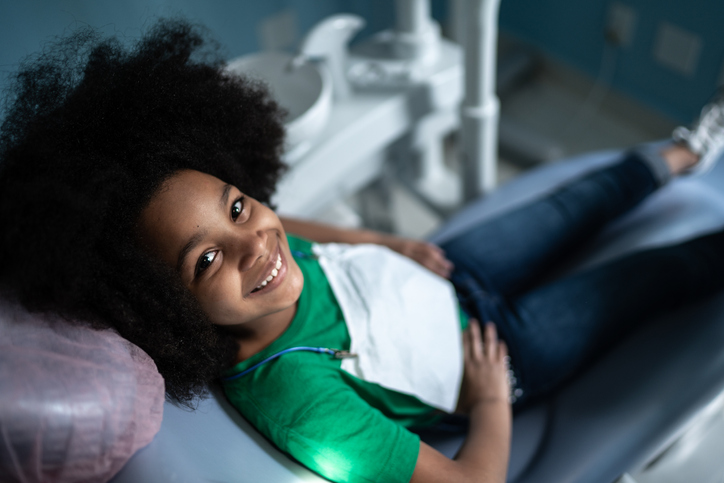 Portrait of a cute girl sitting on dentist's chair