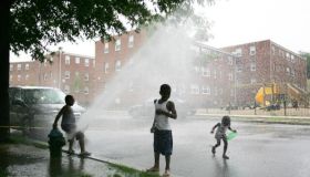 Children play in the spray of an opened