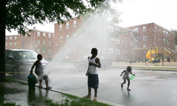 Children play in the spray of an opened
