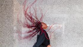 Young woman tossing hair by wall