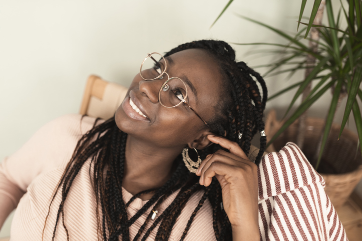 Portrait of a beautiful African woman sitting and day dreaming at home