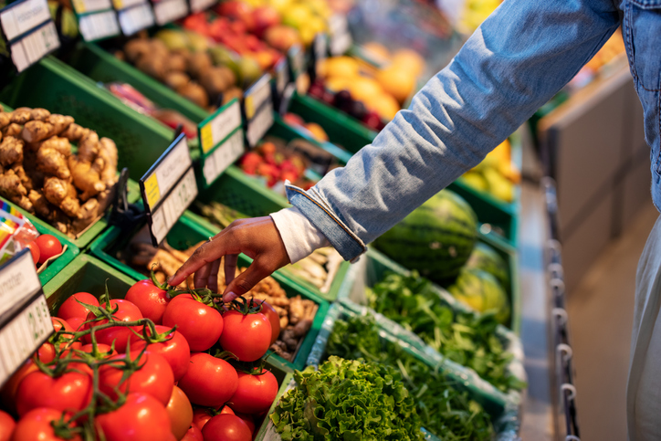 Woman buying fresh vegetables at supermarket