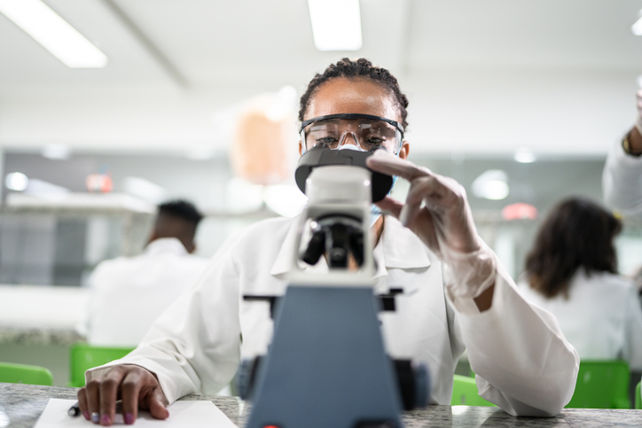 Woman looking in the microscope in the laboratory