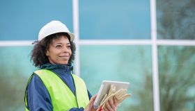 Woman is monitoring job site and using digital tablet