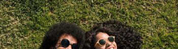 Happy couple wearing sunglasses lying on grass