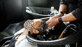 Black Woman getting a hair wash by male hairdresser at hair salon