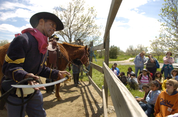 (ga) CDCIVILWAR--AURORA, COLORADO, MAY 2 2007-- Antonio Johnson, dressed as a post-Civil War African American calvary soldier, explains to Aurora school children the difference between a saber, which he is holding and has only one sharp edge, and a sword